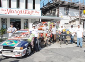 Energy transferred! Racers Gavin Gouveia (left) Gregory Lopes (third from left) and Shane Ali (extreme right) pose in front of their machines at the Rip It sponsorship presentation at the Margarita Gift Shop on Middle Street yesterday.  