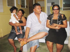 Magistrate Geeta Chandan-Persid Edmond (right) with her swollen lips and torn shirt, sitting next to her husband, Joel Persid-Edmond while her babysitter, Sarita Hardat holds the couple’s baby, Simran.