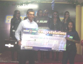 Courts Stash of Cash winner, Shoba Harrichand, receiving her cheque from country manager Lester Alvis. 