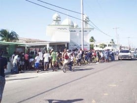 Persons wait outside the Prashad Nagar Mosque hoping to get some beef as Muslims celebrated Eid-ul-Adha yesterday. (Gaulbert Sutherland photo)