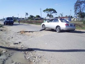 One of many enormous potholes on Dennis Street. This one, just behind the University of Guyana campus is a motorists’ nightmare and reportedly came about as a result of the Guyana Water Inc digging to get to a pipeline. (Gaulbert Sutherland photo)