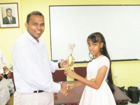 Crystal Khan, a student attending the Stewartville Secondary School on the West Coast, looks radiant as she receives her elegant chess trophy from Dr Frank Anthony, Minister of Culture, Youth and Sport. Crystal is the lone female to qualify for participation in this year’s invitational National Junior Chess Championship. She placed second to National Junior Champion Cecil Cox, but defeated him in their individual encounter and was the only player to do so. Crystal said she represented a nation of schoolgirls in chess with her participation, and success, in the National Junior Championship.