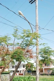 A street light in Bel Air Village leaning dangerously against an electricity post (Photo by Jules Gibson)