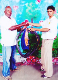 In picture Nashane Jaundoo receives the cycling equipment from Flying Ace Cycle Club Randolph Roberts.