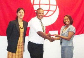 Rawl Davson, Vice-President of the Guyana Hockey Board receives the sponsorship cheque from Jennifer Cipriani, Manager of Products and Marketing of Scotia Bank Limited while Tricia Fiedtkou - Assistant Secretary/Treasurer of the GHB looks on. 