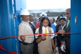Prime Minister Samuel Hinds (left) and President Bharrat Jagdeo (right) look on as a Queen’s College student cuts the ribbon officially declaring the new GPL Kingston Power Plant open.
