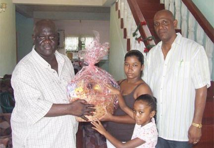 As part of its activities during the festive season, the Guyana Police Force presented hampers to the relatives of police ranks who were killed in the line of duty. In the photo Commissioner of Police Henry Greene delivers hampers to the daughter of the late Constable Feroze Bashier in the presence of her mother. Looking on (right) is Divisional Commander of ‘A’ Division, Assistant Commissioner George Vyphuis. (Photo courtesy of the GPF)