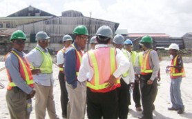 Minister Robert Persaud (third from left) interacts with engineers and other GuySuCo personnel at the construction site of the new Enmore packaging plant yesterday. 