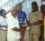 Mohanlall Dinanauth receives his trophy from A. H and L Kissoon Managing Director Hemraj Kissoon in the presence of other players and officials of the Lusignan Golf Club. 					