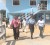 Region Four RDC councillor Maureen Philadelphia of the PNCR-1G, left, being escorted by a police rank to the Beterverwagting Police Station yesterday.  