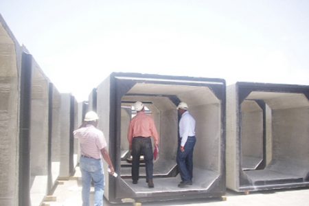 Officials of Courtney Benn Construction company inspect one of the pre-cast concrete units on Main Street yesterday.