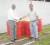 SOL Guyana Director Ken Figaro and GMTCS Country Coordinator Romeo De Freitas (at right) enjoy a handshake in front of six of 30 drums of fuel the company contributed to marine turtle conservation efforts.  