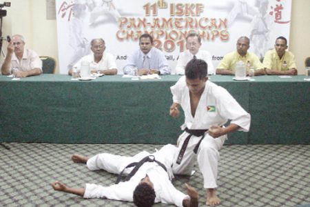 Karatekas Eric Hing (right) and Roger Peroune demonstrate a kumite move in front of Sport Minister Dr. Frank Anthony (third from left). Also in the photo are (from left) Instructor from the YMCA dojo Amir Khouri (left) Reverend Compton Meerabux, Vice Chairman of the ISKF Pan American Championships Committee Shaun Mc Grath, President of the GKC Reeaz Hussain and Instructor of the GKC Jeffrey Wong. (Orlando Charles photo)   
