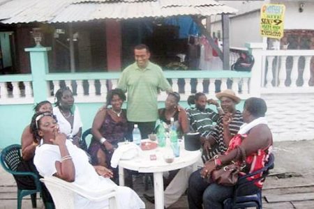 Minister of Agriculture, Robert Persaud (standing) chats with residents of Buxton. (Gina photo)