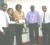 Picture shows Helen Browman (centre) receiving the cheques in settlement from left Y. Arjune (NAFICO), Nadia Sagar (GTM) and Vibert Austin (United) 2nd from right. At right is Bish Panday.