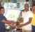 Stabroek Market’s skipper Ryan Boodhoo, right, receives the winner’s trophy from AN Electronics Manager Kapil Hariprashad. 