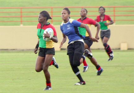 Guyana’s Collette Hope (with ball) leaves a St. Lucia defender in her trail en route to the try-line yesterday at the National Stadium, Providence (Orlando Charles photo)