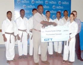 GT&T’s Wystan Robertson hands over the cheque to a representative of the Guyana Karate College. (Orlando Charles photo)