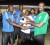 Young Achievers Captain Randy Adams (left) receives the $20,000 prize from Tournament Organiser Adolph Davis for being the top team of the month on Saturday.