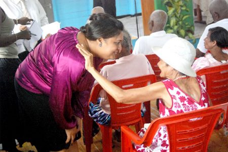 Minister of Human Services interacts with a senior citizen at the launch of Month of the Elderly yesterday at the Palms.  (Jules Gibson photo)