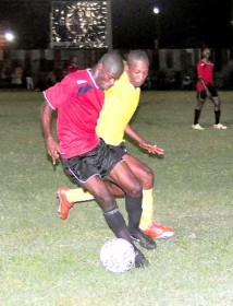 Alpha United’s Dwight Peters (left) controls ball possession for his team in their clash with Buxton United on Friday at the Georgetown Football Club (GFC) Ground. (Orlando Charles Photo)