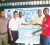 Tropical Mist Brand Manager Errol Nelson (left) presents the water to Derrick Carter goalkeeper of BK Western Tigers in the presence of Dexter Cush, Oselmo Peters and Mortimer Stewart.
