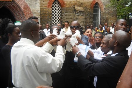 Relatives and close associates of Winston Murray about to release doves following the funeral service in Leguan today. 