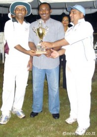 Captain of the Trinidad and Tobago lawyers cricket team, Krishna Jaglal, left, and Guyana captain, Sanjeev Datadin, right, are presented with the trophy. (Newsday photo)