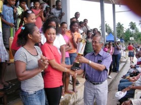 Winston Murray hands over a trophy to a participant at the Day of Sports for Youth held at the Christianburg Community Centre Ground in September.