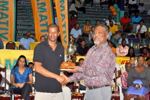 KING AGAIN! Godfrey Munroe is making a habit of winning national table tennis titles while not playing very much table tennis an indictment against the present crop. Above, a smiling Munroe receives his trophy from Prime Minister Sam Hinds. (Orlando Charles photo)