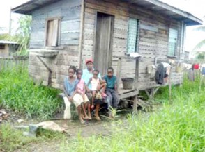 Jacqueline Cato and four of her five children sitting in front of their home days after her husband was brutally murdered.