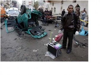 An Egyptian police officer stands next to the remains of a car which exploded in front of the Coptic Orthodox church in Alexandria, 230 km (140 miles) north of Cairo January 1, 2011.  REUTERS/Amr Abdallah Dalsh