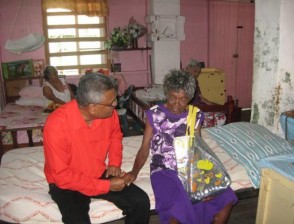 Minister Manzoor Nadir greets the oldest resident of the Palms, Ruby Wilkinson, who is 101 years old. (GINA photo)