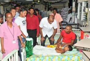 President Bharrat Jagdeo wishing a child at the paediatric unit of the Georgetown Public Hospital Corporation a merry Christmas in the presence of West Indies batsmen Shivnarine Chanderpaul and Ramnaresh Sarwan. (GINA photo)