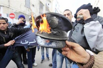 Rioters burn a policeman’s hat during clashes with the police in downtown Tunis yesterday. (REUTERS/Zohra Bensemra)