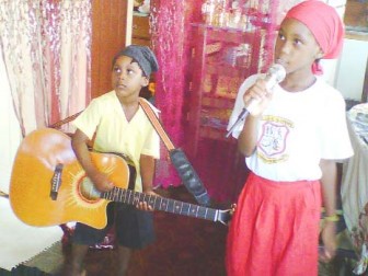Akinsanya on guitar and his older sister, Abasede Bejde Fabayo Mwanza performing a Michael Jackson number.