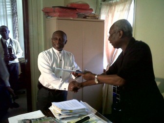 Carl Greenidge (left) hands over his papers to PNCR General Secretary Oscar Clarke