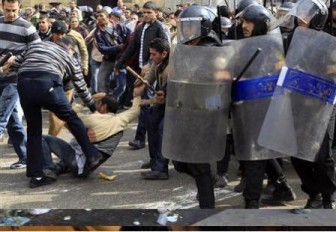 A plainclothes policeman hits a protester during a demonstration in Cairo January 28, 2011.  REUTERS/Goran Tomasevic