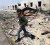 A rebel fighter walks amid debris at Brega, after forces loyal to Muammar Gaddafi fled westward following coalition air strikes in eastern Libya, yesterday. (REUTERS/Finbarr O’Reilly)