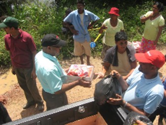 Neaz Subhan (second-left) and other members of the IAC distributing food stuff and cleaning aids to residents of New Forest Canje, Berbice recently.