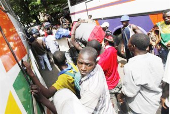 Malians carry their belongings as they wait for transport to return to their country, along a street near the Mali Embassy, in Abidjan, March 30, 2011. (Reuters/Thierry Gouegnon)