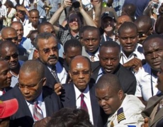 Haiti's former President Jean-Bertrand Aristide, center, arrives to the airport in Port-au-Prince, Haiti. 