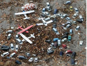 Cars and airplanes swept by a tsunami are pictured among debris at Sendai Airport, northeastern Japan today.  REUTERS/KYODO