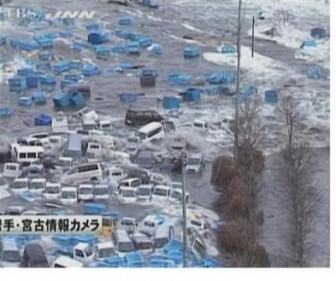 Cars and containers are swept by a tsunami wave in Miyako port, March 11, 2011. REUTERS/TBS via REUTERS TV