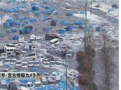 Cars and containers are swept by a tsunami wave in Miyako port, March 11, 2011. REUTERS/TBS via REUTERS TV