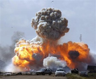 Vehicles belonging to forces loyal to Libyan leader Muammar Gaddafi explode after an air strike by coalition forces, along a road between Benghazi and Ajdabiyah March 20, 2011. REUTERS/Goran Tomasevic