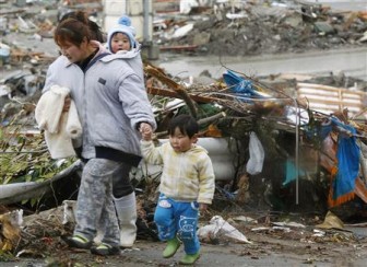 A family walks past rubble after the earthquake and tsunami in Minamisanriku City, Miyagi Prefecture, northeastern Japan March 16, 2011. REUTERS/Kyodo