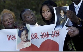 Geraldine Sword (left), the Reverend Olivia Williams and Emani Washington at Oakland's Evergreen Cemetery, holding photos of young victims.