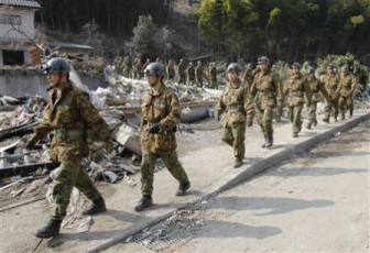 Soldiers from Japan's Self Defence Force arrive at the scene of devastation before searching for victims among the rubble, after a magnitude 8.9 earthquake and tsunami struck Rikuzentakata, northern Japan March 13, 2011. REUTERS/Toru Hanai