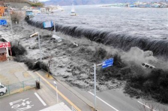 The wave from a tsunami crashes over a street in Miyako City, Iwate Prefecture in northeastern Japan after the magnitude 8.9 earthquake struck the area March 11, 2011. Picture taken March 11, 2011. REUTERS/Mainichi Shimbun
